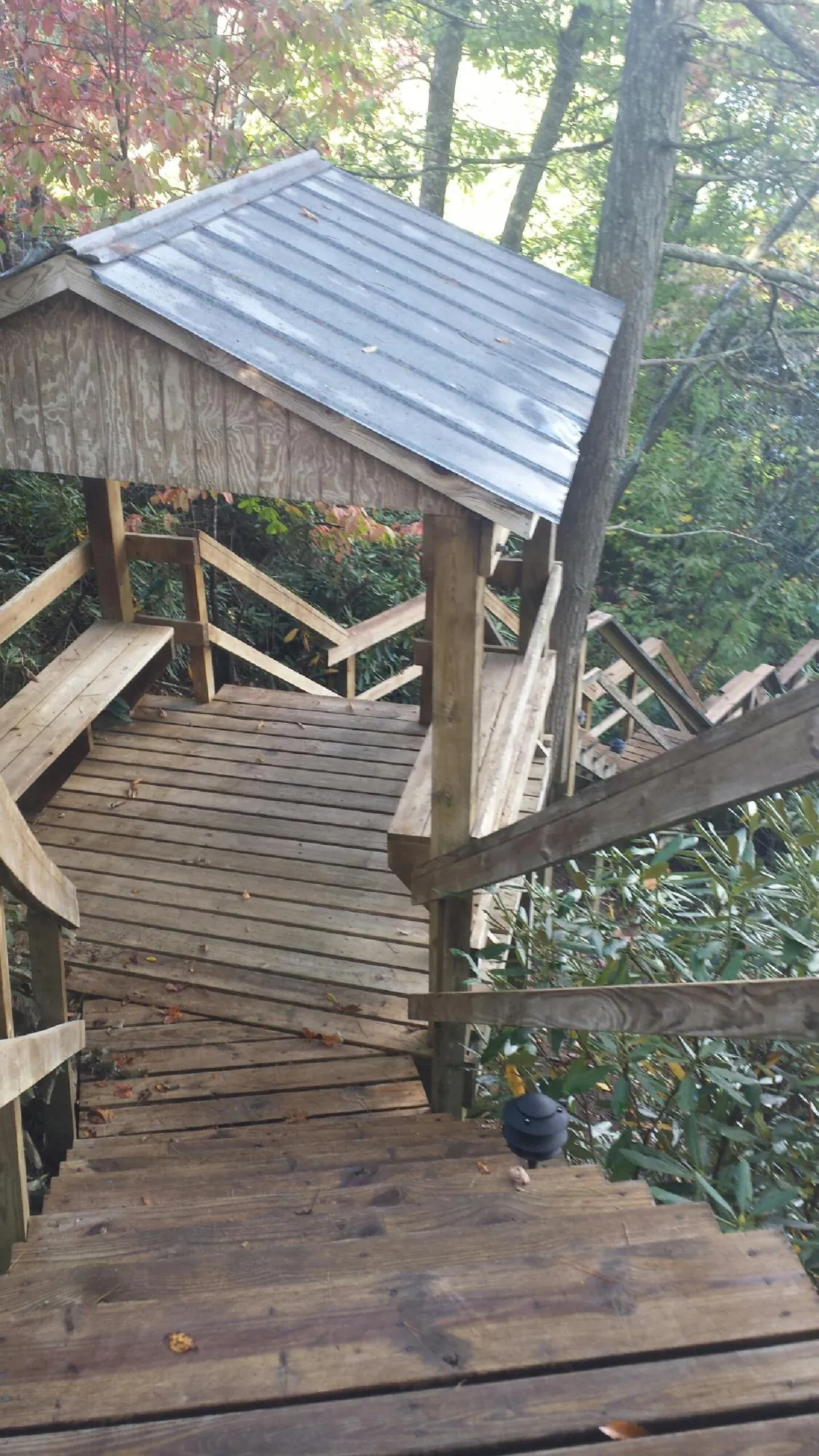 Metal roofed shelter over wooden steps on a wooded walkway — Skylight Repair & Installation work by our crew in Contoocook