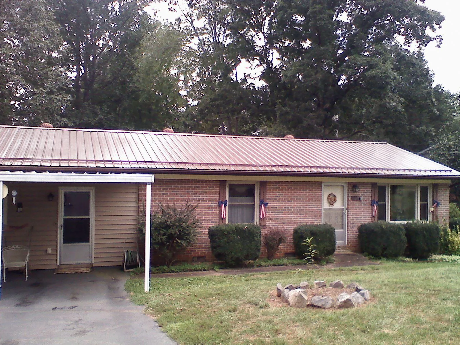 Bronze metal roof and carport on a brick ranch home — Roof Repair work by our crew in Contoocook